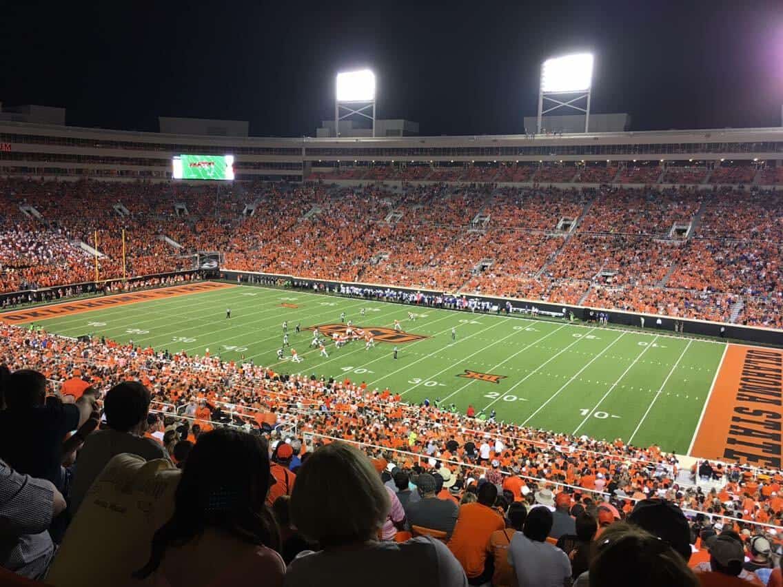 View of Boone Pickens Stadium during a night football game with fans in the stands.